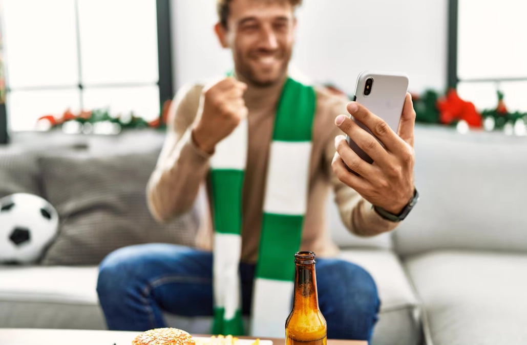 Man supporting soccer match using smartphone